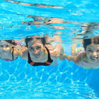 Three young people swimming under water.